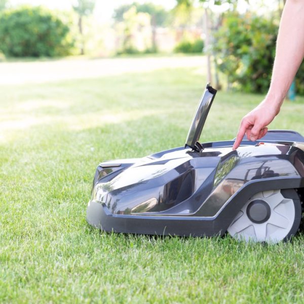Rasen Roboter, Mähroboter mit Hand beim Einschalten, Hintergrund, Zukunft